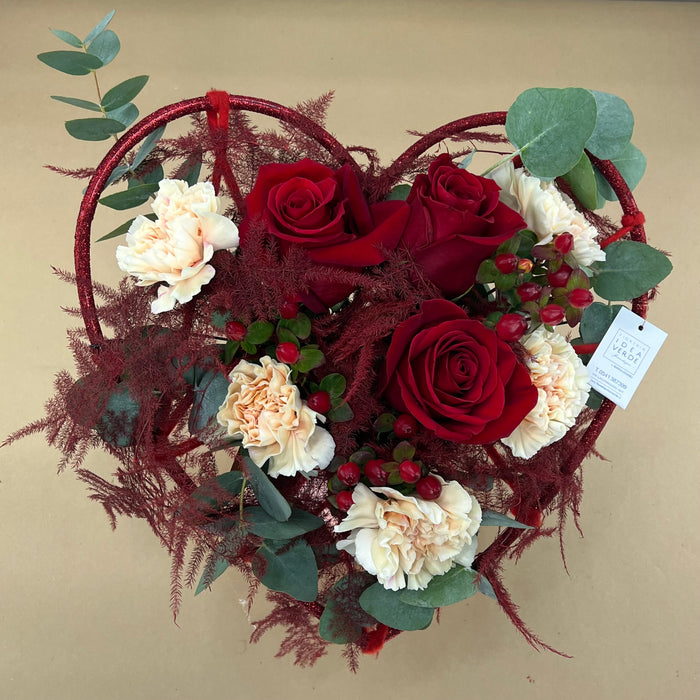 Struttura bouquet a cuore con rose rosse, garofani e bacche rosse
