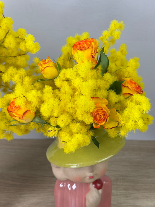 White ceramic head vase with mimosa and various flowers