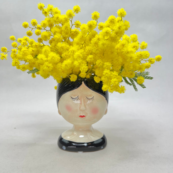White ceramic head vase with mimosa and various flowers