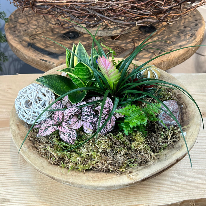 Composizione floreale con piante in vaso di legno